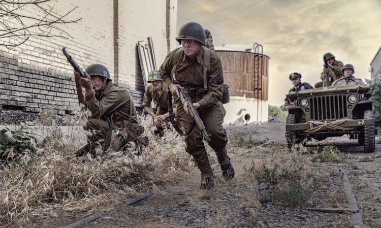World War II army infantry are on the look out for the enemies as they manuever forward on the battle front. (filtered)
